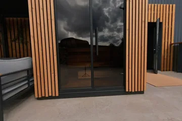 Leil Patio S, patio · Exterior: The Patio sauna on the Leil factory terrace. The covered seating area beside it is a separate structure.