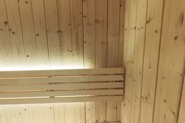 SaunaLife X7, bench corner: A view along the bench and illuminated backrest.